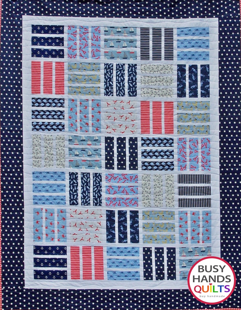 May include: A navy blue and white quilt with a nautical theme. The quilt is made up of various squares with different patterns, including anchors, sailboats, stripes, and seashells. The quilt is bordered with a navy blue fabric with white stars. The quilt is labeled "Busy Hands Quilts" in the bottom right corner.