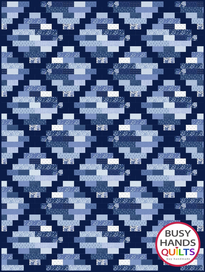 May include: A blue and white quilt with a geometric pattern. The quilt is made up of squares and rectangles of different shades of blue and white. The quilt is edged with a dark blue border. The quilt is made by Busy Hands Quilts.