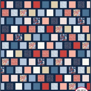 Op de afbeelding: Een patchworkquilt met een marineblauwe achtergrond. De quilt heeft een herhalend patroon van vierkanten in verschillende kleuren en patronen, waaronder rood, wit, blauw en bloemenprints. De quilt heeft de tekst "Busy Hands Quilts" in een witte cirkel.