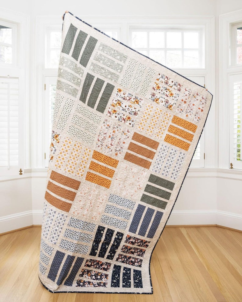 May include: A large quilt with a patchwork design featuring various floral and geometric patterns in shades of brown, blue, green, and white.