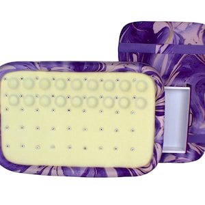 May include: A purple and white marbled jewelry box with a removable tray. The tray has 36 small circles for storing earrings or other small jewelry. The box has a hinged lid and a small drawer.