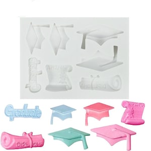 May include: A white silicone mold with various graduation themed shapes, including caps, diplomas, and the word "Graduate".