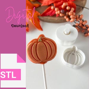 May include: A 3D printed pumpkin lollipop mold with a white finish. The mold is shown with a finished orange pumpkin lollipop with gold glitter accents.