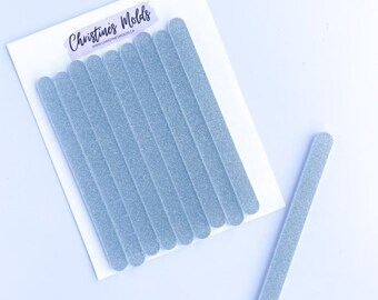 May include: A set of ten light blue glitter nail files. The files are arranged in a row on a white background. The files are all the same size and shape. The text "Christine's Molds" is printed on the white background.