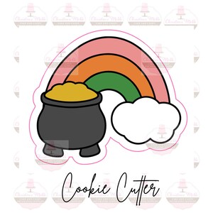 Può includere: Un tagliabiscotti a forma di arcobaleno con un pentolone d'oro e una nuvola. L'arcobaleno ha strisce rosa, arancioni e verdi. Il pentolone è nero e pieno d'oro giallo. Il testo "Cookie Cutter" è sotto.