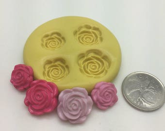 Può includere: Uno stampo in silicone con quattro cavità a forma di rosa. Cinque rose rosa e rosse sono mostrate accanto allo stampo, mostrando la dimensione del prodotto finito.