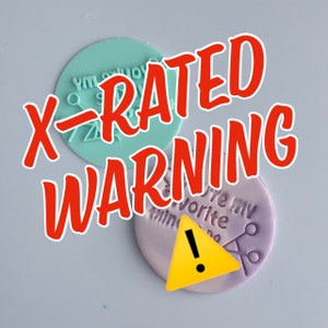 Puede incluir: Dos sellos redondos de silicona de colores con texto. El primer sello es azul claro con el texto "You're my favorite thing" en blanco. El segundo sello es morado con el texto "You're my favorite thing" en blanco. El texto "X-RATED WARNING" está en rojo y se superpone a los sellos.
