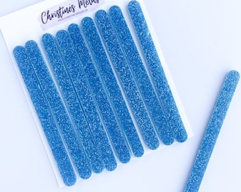 May include: Ten blue glitter resin sticks, with rounded edges, on a white background. The sticks are arranged in a row, with one stick extending out to the right. The text "Christines Molds" is printed on the white background.