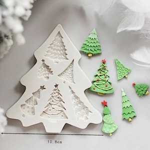 Op de afbeelding: Witte siliconen mal in de vorm van een kerstboom met 7 verschillende kerstboomontwerpen. De mal is 10,8 cm breed.