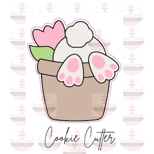 May include: A cookie cutter shaped like a bunny rabbit sitting in a pot with a flower. The bunny is white with pink feet and a white tail. The pot is brown and the flower is green with pink petals.