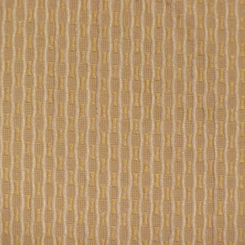 May include: Detailed view of a textured fabric with a repeating pattern. The design features vertical columns of alternating beige and off-white, creating a subtle, woven effect. The fabric has a slightly raised, tactile surface.