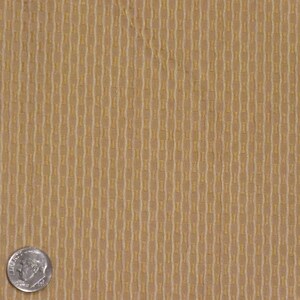 May include: Close-up of a tan fabric with a repeating vertical pattern. The pattern consists of elongated, interconnected shapes in a lighter shade of tan, creating a textured appearance. A U.S. dime is in the lower left corner for scale.
