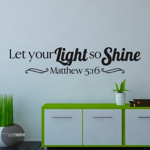 Puede incluir: Pegatina de pared en blanco y negro con el texto "Let your light so shine Matthew 5:16". La pegatina está en una pared blanca con un armario verde y una planta en maceta en primer plano.
