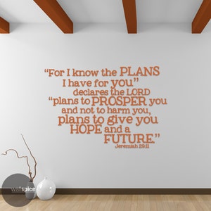 Puede incluir: Decoración de pared con texto naranja sobre fondo blanco. Cita de Jeremías 29:11: «Porque yo sé los planes que tengo para vosotros... planes de bienestar... para daros el porvenir y la esperanza.»