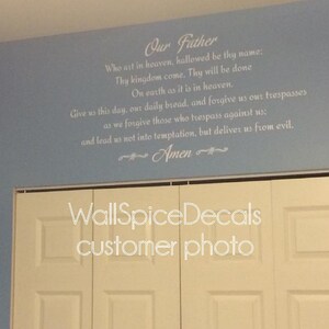 May include: A light blue wall featuring the Lord's Prayer in white text. The text begins with "Our Father" and continues with the prayer's verses. The word "Amen" is at the end. A white closet door is visible at the bottom.