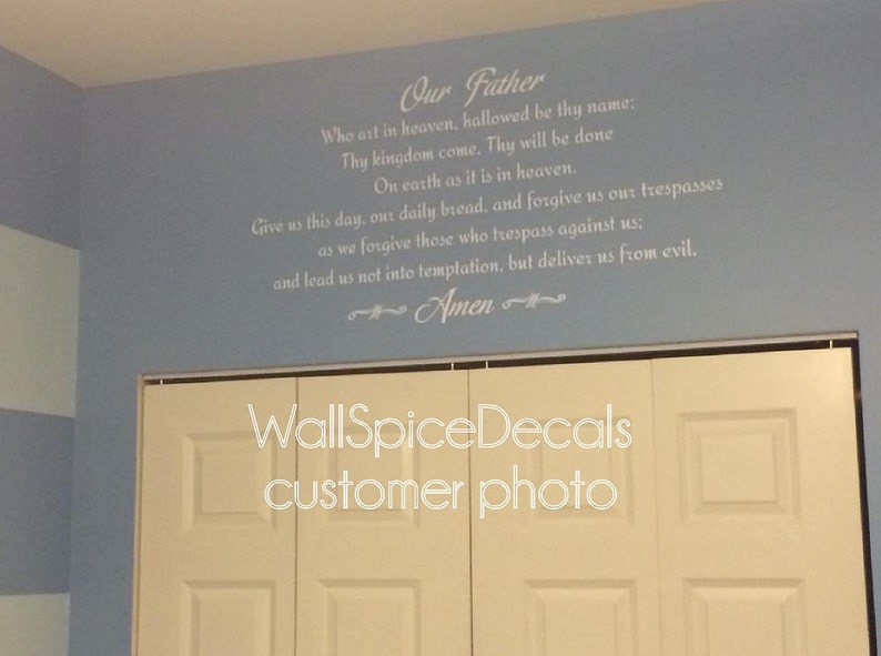 May include: A light blue wall featuring the Lord's Prayer in white text. The text begins with "Our Father" and continues with the prayer's verses. The word "Amen" is at the end. A white closet door is visible at the bottom.