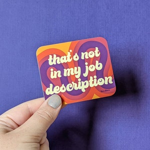 May include: A sticker with a retro design featuring the text "that's not in my job description". The sticker has a colorful swirl pattern in shades of orange, yellow, red, and purple.