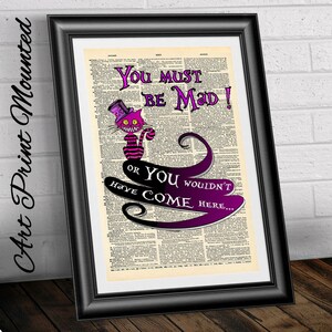 Pu&ograve; includere: Una pagina di dizionario vintage con un'illustrazione viola e rosa del Gatto del Cheshire di Alice nel Paese delle Meraviglie. Il testo dice "You must be mad! Or you wouldn't have come here..."