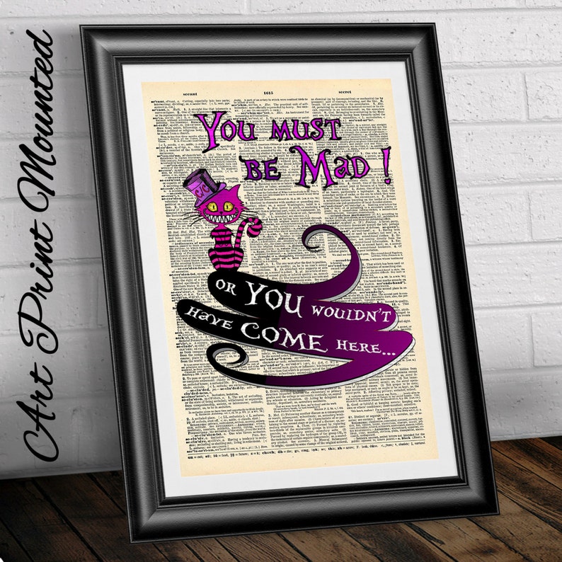 Pu&ograve; includere: Una pagina di dizionario vintage con un'illustrazione viola e rosa del Gatto del Cheshire di Alice nel Paese delle Meraviglie. Il testo dice "You must be mad! Or you wouldn't have come here..."