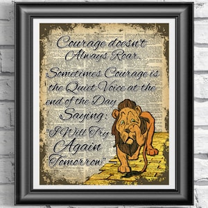 May include: A vintage dictionary page with a quote about courage featuring a cartoon lion walking on a yellow brick road. The quote reads "Courage doesn't always roar. Sometimes courage is the quiet voice at the end of the day saying: 'I will try again tomorrow.'"