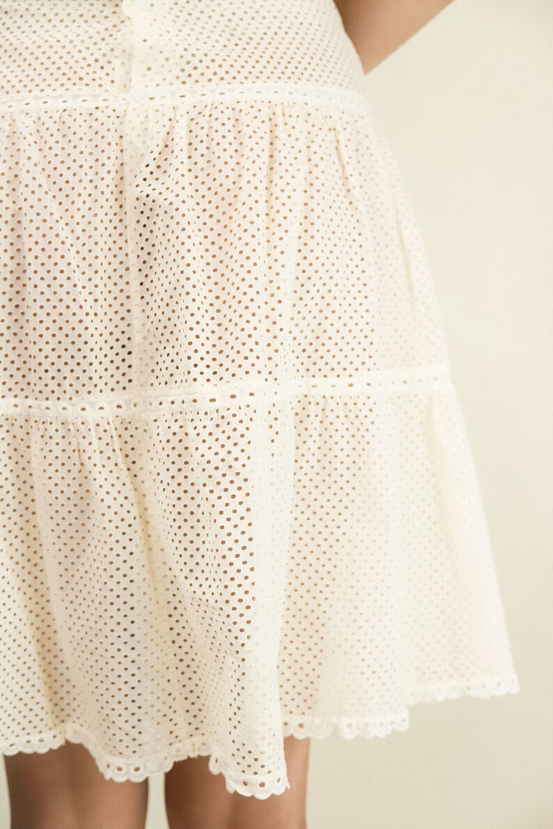May include: A white tiered skirt with a dotted pattern and a scalloped hem.