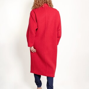 May include: A long, red coat with a high collar. The coat is made of a soft, fuzzy material and has a relaxed fit.