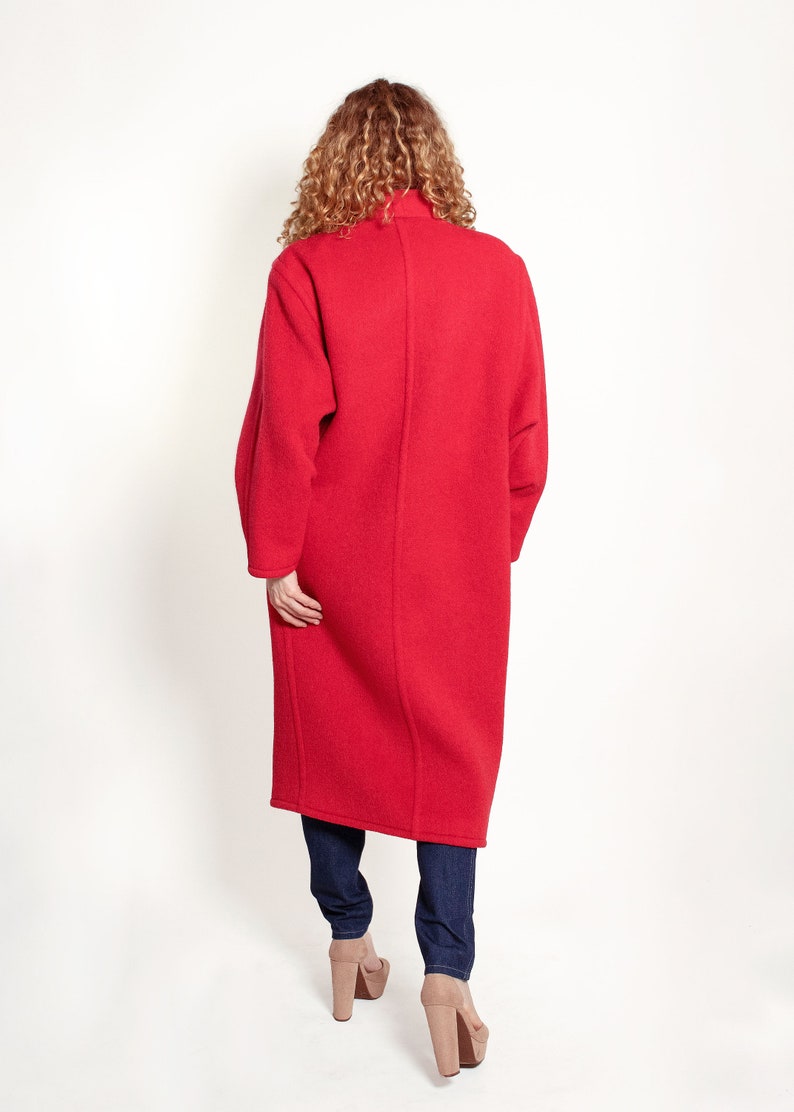 May include: A long, red coat with a high collar. The coat is made of a soft, fuzzy material and has a relaxed fit.