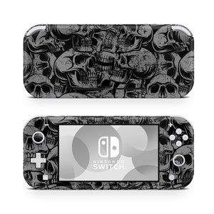 Può includere: Una skin per console Nintendo Switch Lite nera e grigia con un motivo a teschi. La skin presenta un design in stile grunge usurato con più teschi di diverse dimensioni e posizioni.