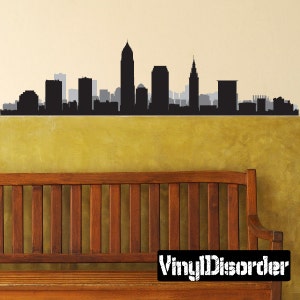May include: Black and white silhouette of the Cleveland skyline, featuring the iconic Terminal Tower, against a yellow wall. The skyline is a vinyl decal, and the text "Vinyl Disorder" is visible in the bottom right corner of the image.
