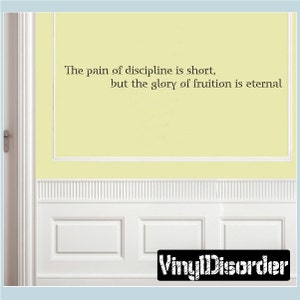 May include: A wall decal with the quote "The pain of discipline is short, but the glory of fruition is eternal." The decal is on a light yellow wall with white wainscoting.