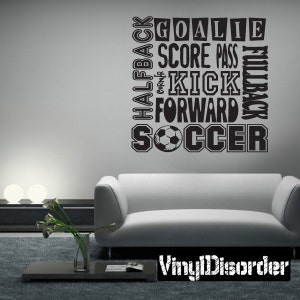 Puede incluir: Pegatina de pared en blanco y negro con temática de fútbol con las palabras "Goalie", "Score", "Pass", "Kick", "Forward", "Halfback", "Corner" y "Soccer" dispuestas en forma de cuadrado. Un balón de fútbol se encuentra en el centro del cuadrado.