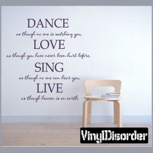 May include: A wall decal with a motivational quote: "Dance as though no one is watching you, Love as though you have never been hurt before, Sing as though no one can hear you, Live as though heaven is on earth." The decal is on a light gray wall with a wooden chair in front of it.