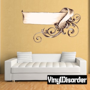 May include: A decorative wall decal featuring a vintage-style banner with ornate scrollwork. The banner is blank, allowing for personalization. The decal is perfect for adding a touch of elegance to any room.