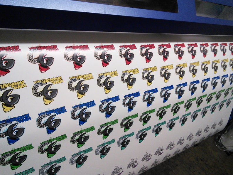 May include: A roll of white sticker paper with colorful printed designs of a number 6 with a chain link design. The stickers are printed in various colors, including red, yellow, blue, green, and black.