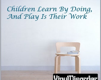 Pode incluir: Uma parede branca com o texto "Children Learn By Doing, And Play Is Their Work" em fonte azul cursiva. Uma cadeira de madeira com um livro no assento fica na frente da parede. O texto "Vinyl Disorder" está em preto e branco na parte inferior da imagem.