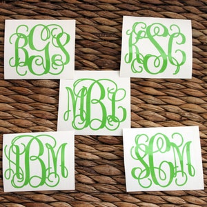 May include: Five white squares with green monogram letters on each. The letters are in a cursive font. The monograms are: RCS, KSC, MBL, IBM, and SGM.