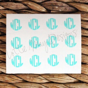 May include: A sheet of white sticker paper with nine turquoise blue monogram stickers. Each sticker features the letters "WCL" in a circle.