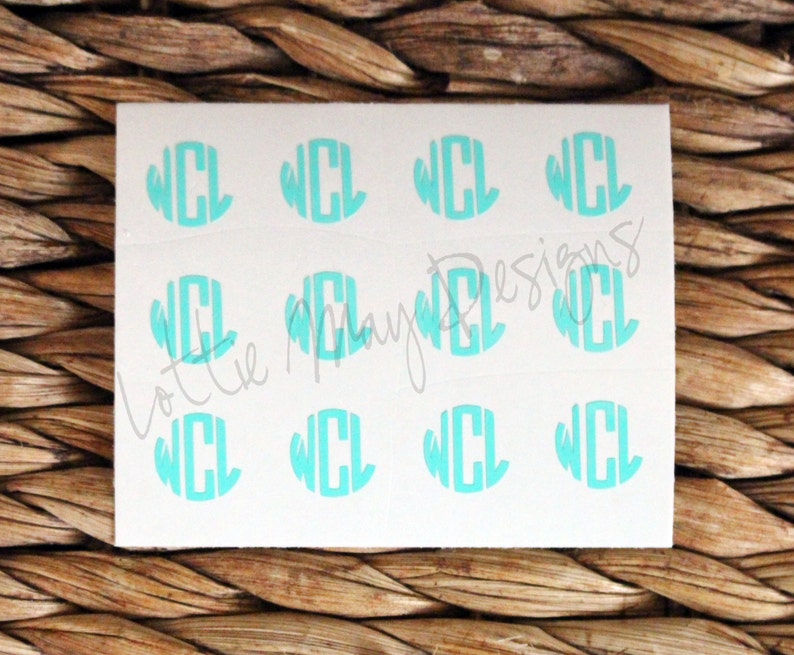May include: A sheet of white sticker paper with nine turquoise blue monogram stickers. Each sticker features the letters "WCL" in a circle.