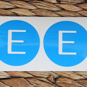 May include: Two blue circles with a white letter E in the center of each circle.