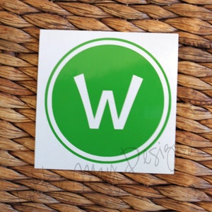 May include: A white square sticker with a green circle and a white letter W in the center. The circle has a white outline.