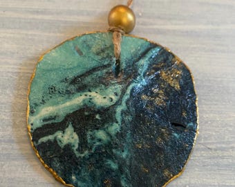 Zanddollarornament, gemarmerde oceaangolf gedecoupeerd, gouden accenten, kerstversiering strandthema
