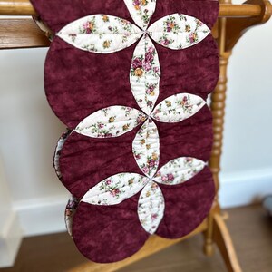 May include: A handmade, wooden cutting board with a natural finish. The board features a live edge on one side and a rectangular shape. It is approximately 18 inches long and 12 inches wide.