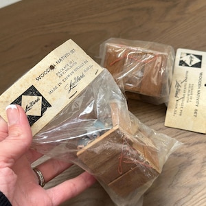 May include: A wooden nativity set packaged in clear plastic. The packaging includes a cardboard label with the text "WOODEN NATIVITY SET" and "Lee Wards". The set appears to be made of wood and includes small figurines.