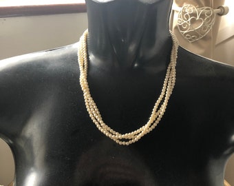 Vintage pretty triple strand ivory faux pearl necklace fastened with a gold effect ring clasp.
