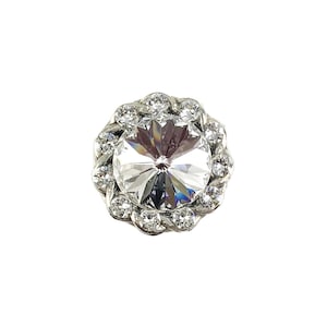 May include: A silver-toned rhinestone embellishment with a clear crystal centre surrounded by smaller rhinestones.