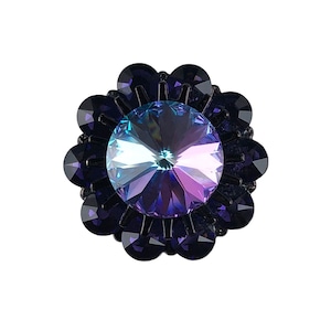 以下が含まれることがあります： 紫と青の虹色のクリスタルが、小さな紫のクリスタルの輪で囲まれ、花の形のデザインになっています。