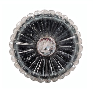 May include: A round, black glass button with a clear crystal center and a silver rim. The button is surrounded by a ring of clear glass beads.