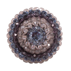 May include: A round, blue and silver beaded brooch with a large, clear blue crystal in the center.
