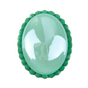 Puede incluir: Un anillo de cabujón ovalado verde con un borde de cristal verde.