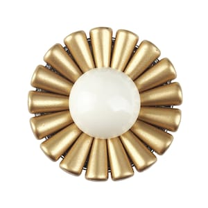 以下が含まれることがあります： 白い中心を持つ金色の花の形をしたブローチ